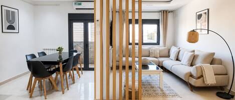Una sala de estar moderna con un sofá, una mesa de centro y un comedor con sillas y una mesa.