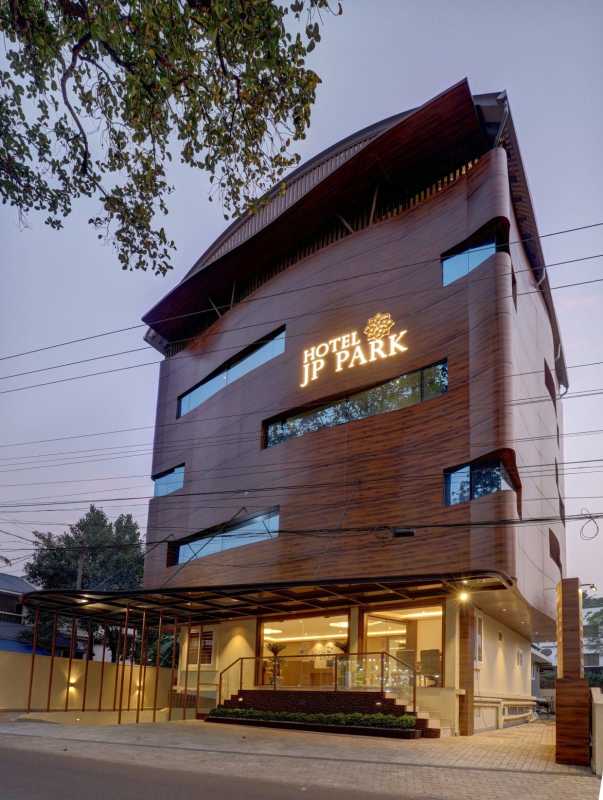 A modern hotel building with a prominent sign reading 'HOTEL JP PARK.'