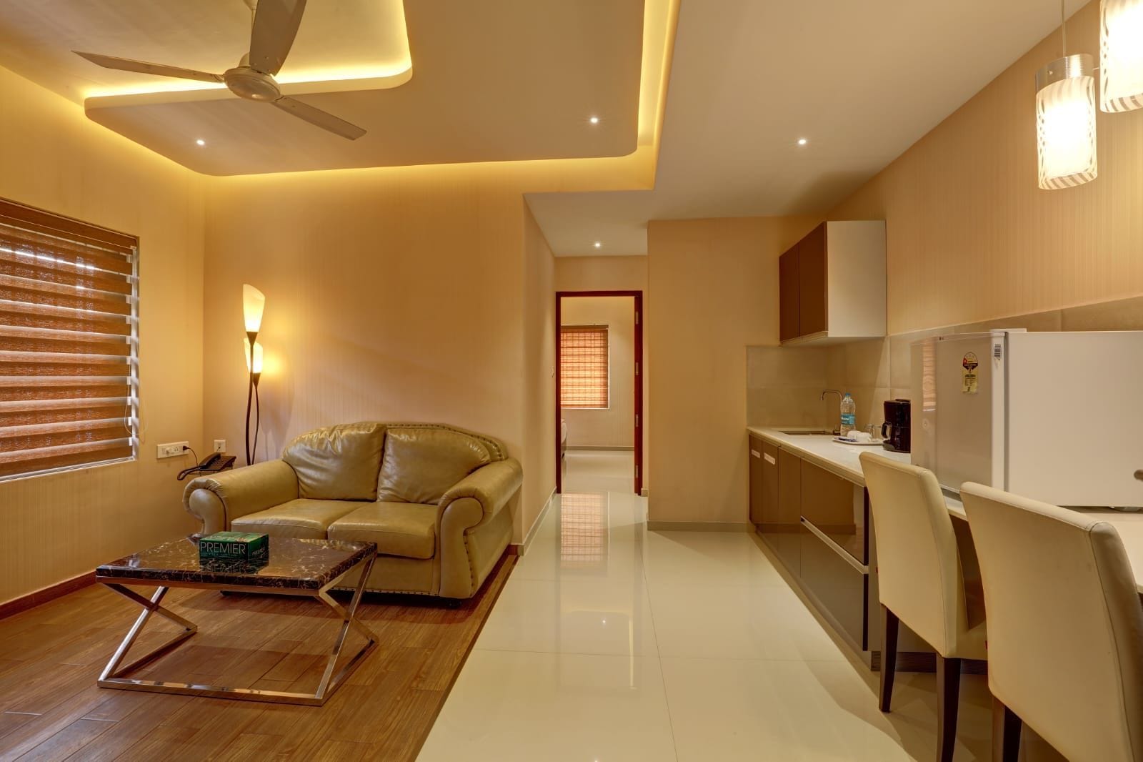 A modern living room with a sofa, a coffee table, and a ceiling fan.