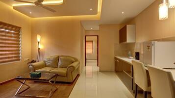 A modern living room with a sofa, a coffee table, and a ceiling fan.