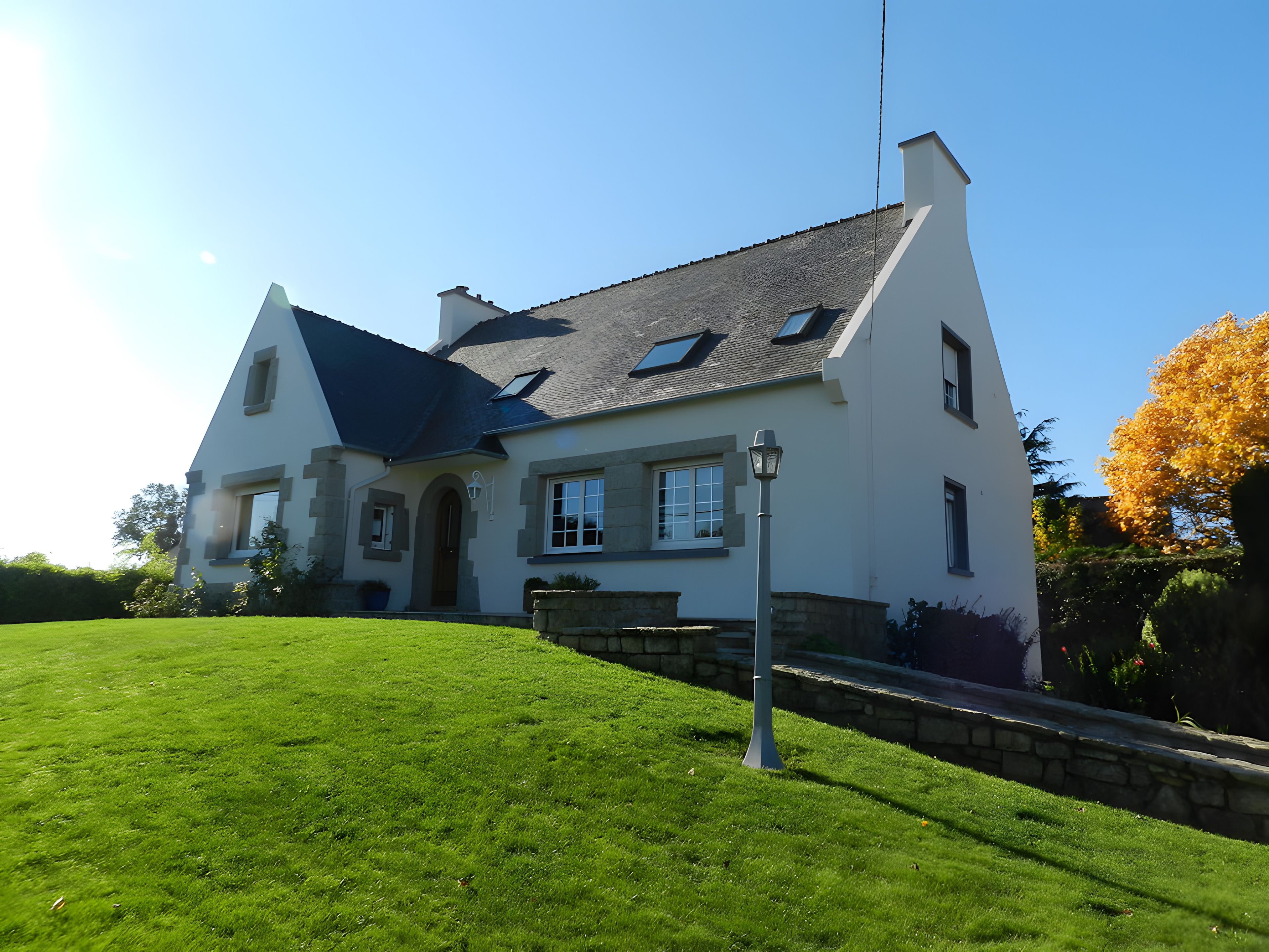 A two-story house with a sloped roof, a front entrance, and a well-maintained lawn.