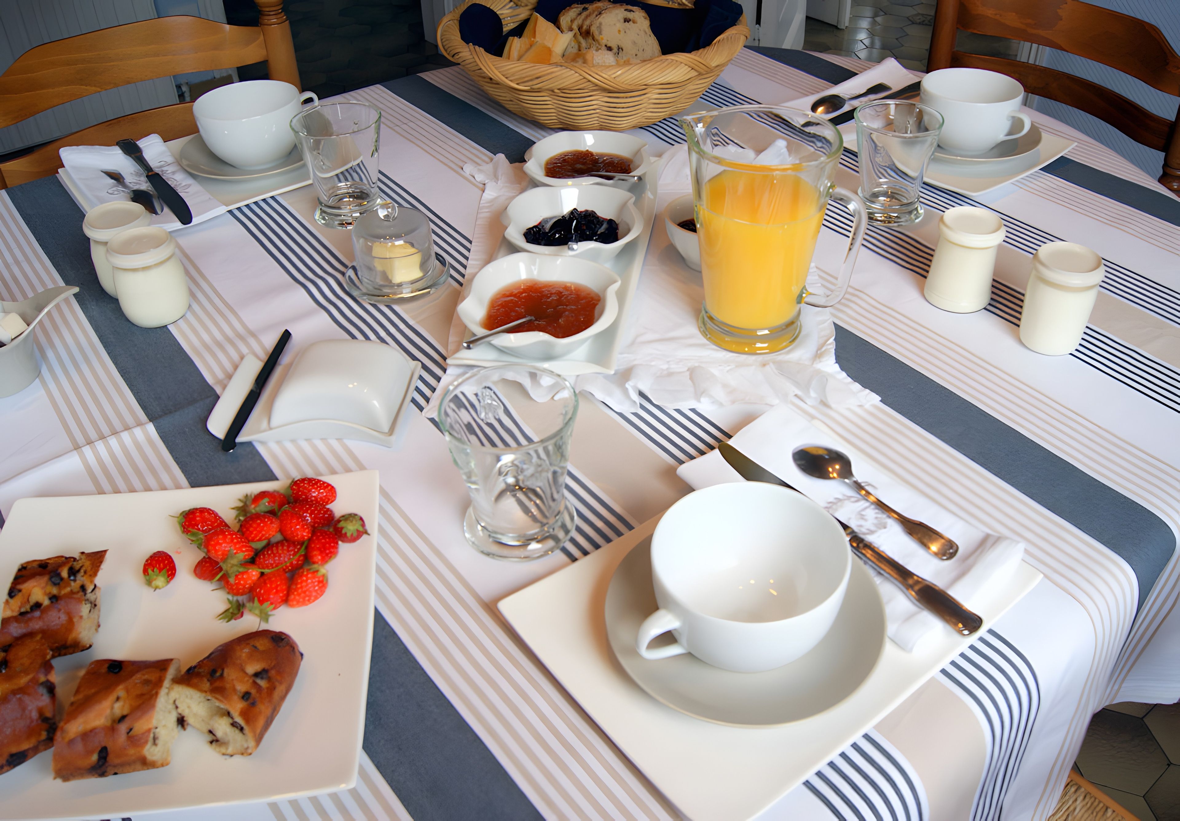 Une table dressée pour le petit-déjeuner, avec une variété d’aliments et de boissons.