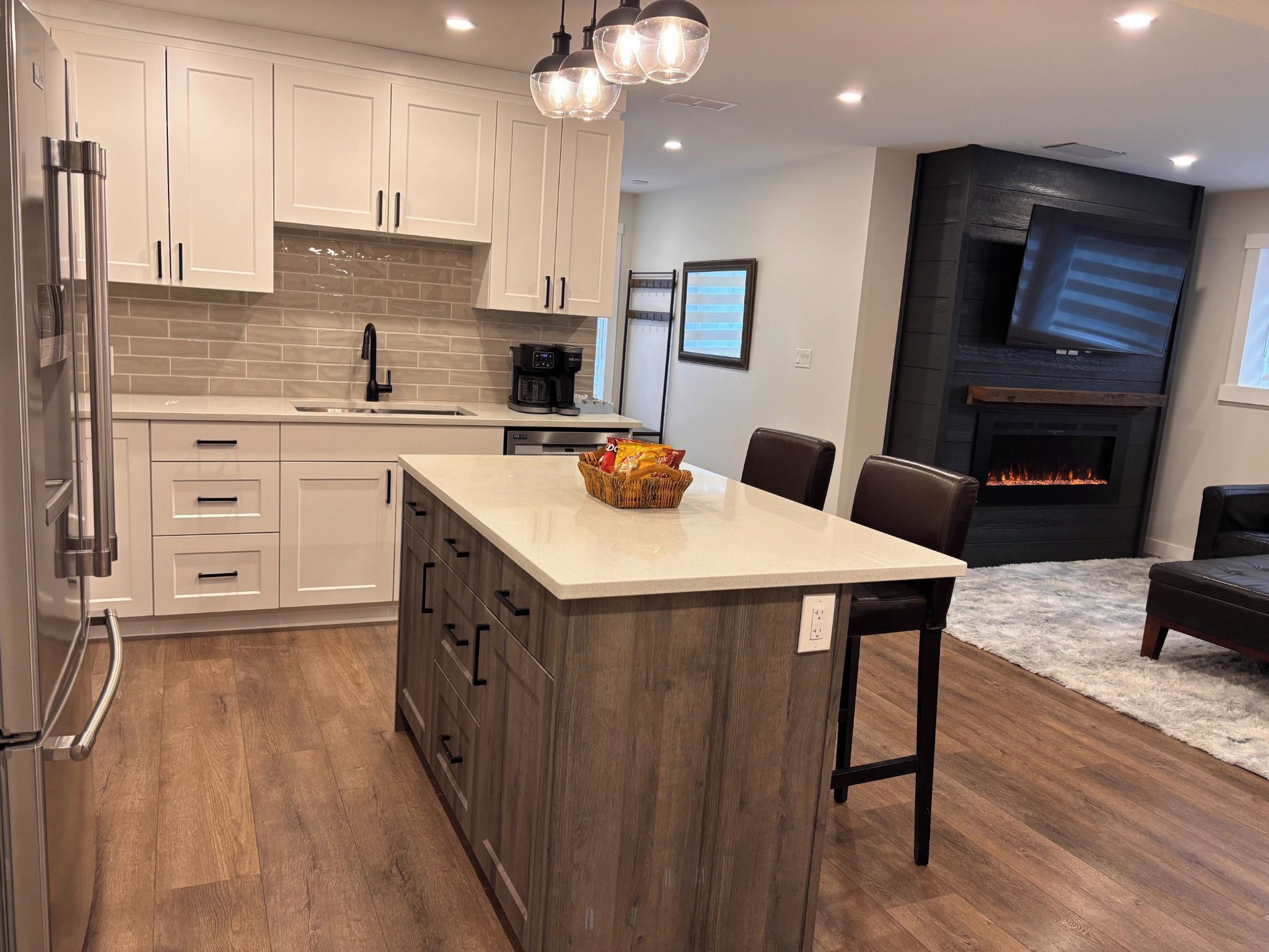 A modern kitchen with a central island, a coffee maker, and a fireplace.