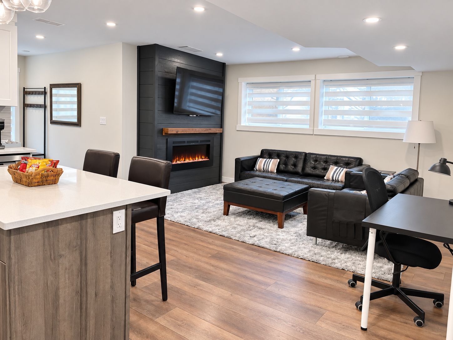 A modern living room with a fireplace, a sofa, a coffee table, and a dining area.