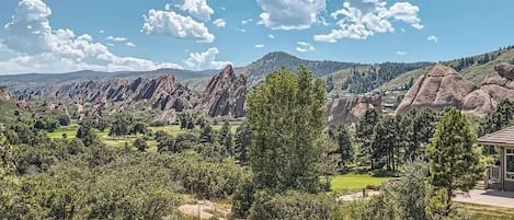 Un paisaje montañoso con un edificio en primer plano.