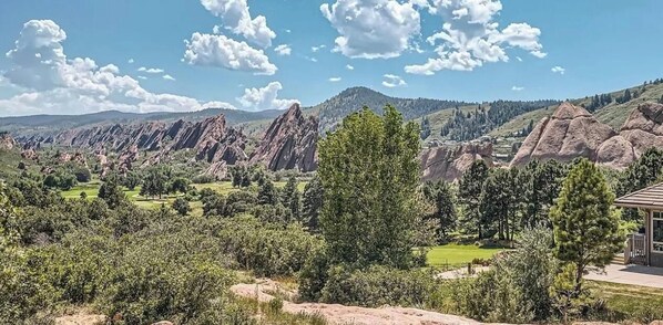 A mountainous landscape with a building in the foreground.
