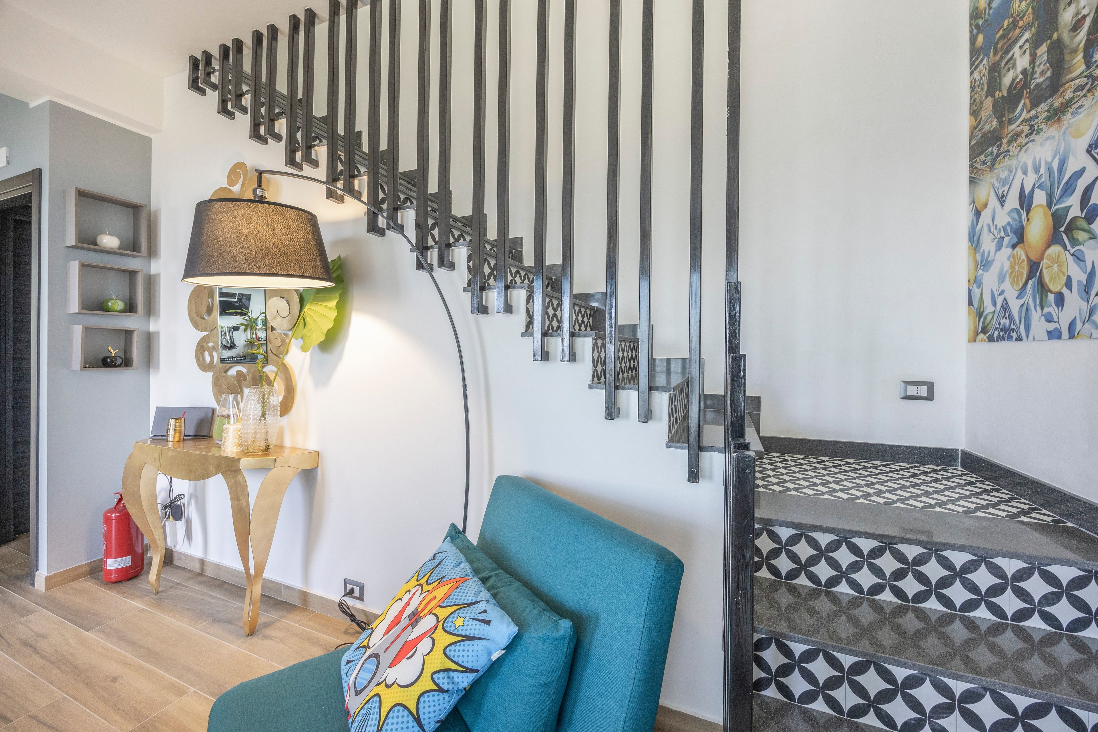 Uma sala de estar moderna com sofá, luminária e escada com ladrilhos estampados.
