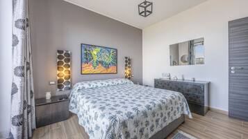Quarto com cama, mesa de cabeceira, cômoda, espelho e um quadro na parede.
