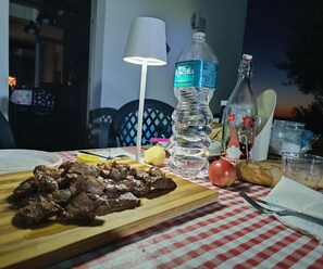 Uma mesa com uma refeição, uma garrafa de água, uma garrafa com etiqueta e um abajur.