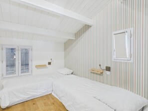A room with two single beds, a window with frosted glass, a striped wall, and a wooden shelf. - Beach 100m away, house for 8, garden & BBQ (Noirmoutier-en-l´Ile)