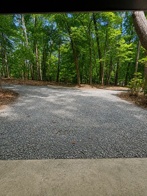 A gravel parking area surrounded by trees. - The Hunters Ridge Retreat (Chapel Hill)