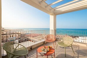 A balcony with a view of the sea, featuring two chairs and a table with a fruit bowl and cups. - Dimora San Francesco - Seaview Terrace w/ Parking (Bari)
