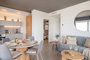 A modern living space with a dining area, a sofa, and a small coffee table. - Dimora San Francesco - Seaview Terrace w/ Parking (Bari)
