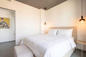 A modern bedroom with a large bed, a bedside table, and a hanging light fixture. - Dimora San Francesco - Seaview Terrace w/ Parking (Bari)