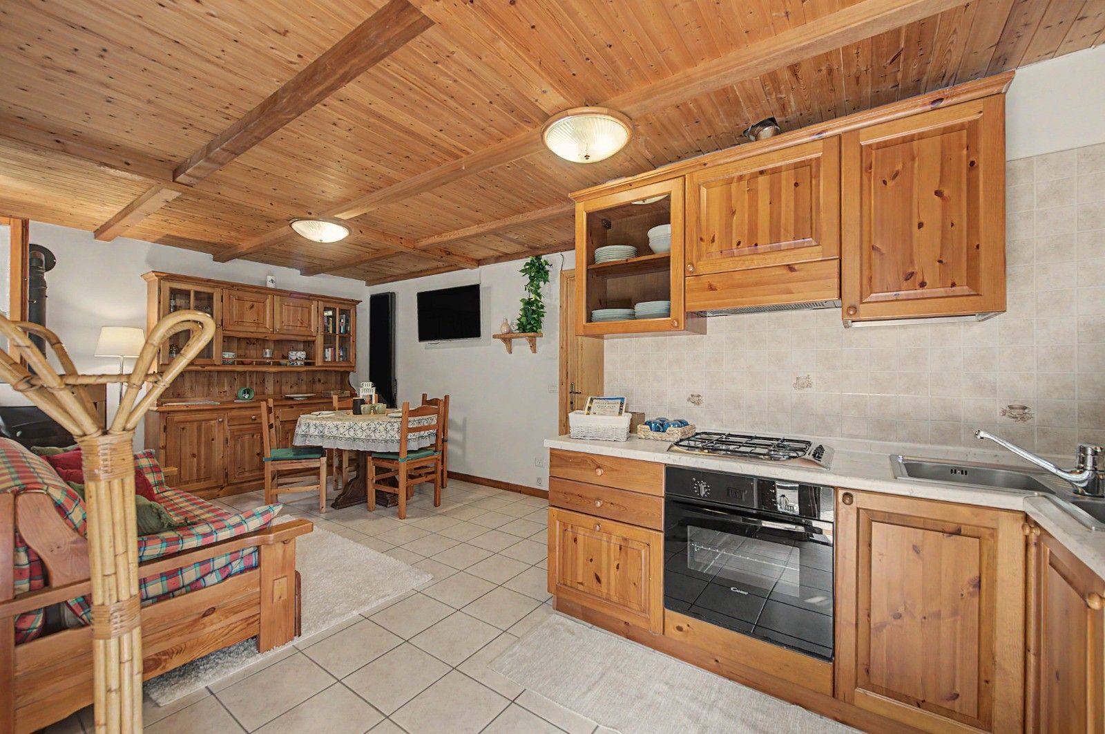 Une cuisine en bois avec un coin repas, comprenant des placards, une cuisinière et un évier.