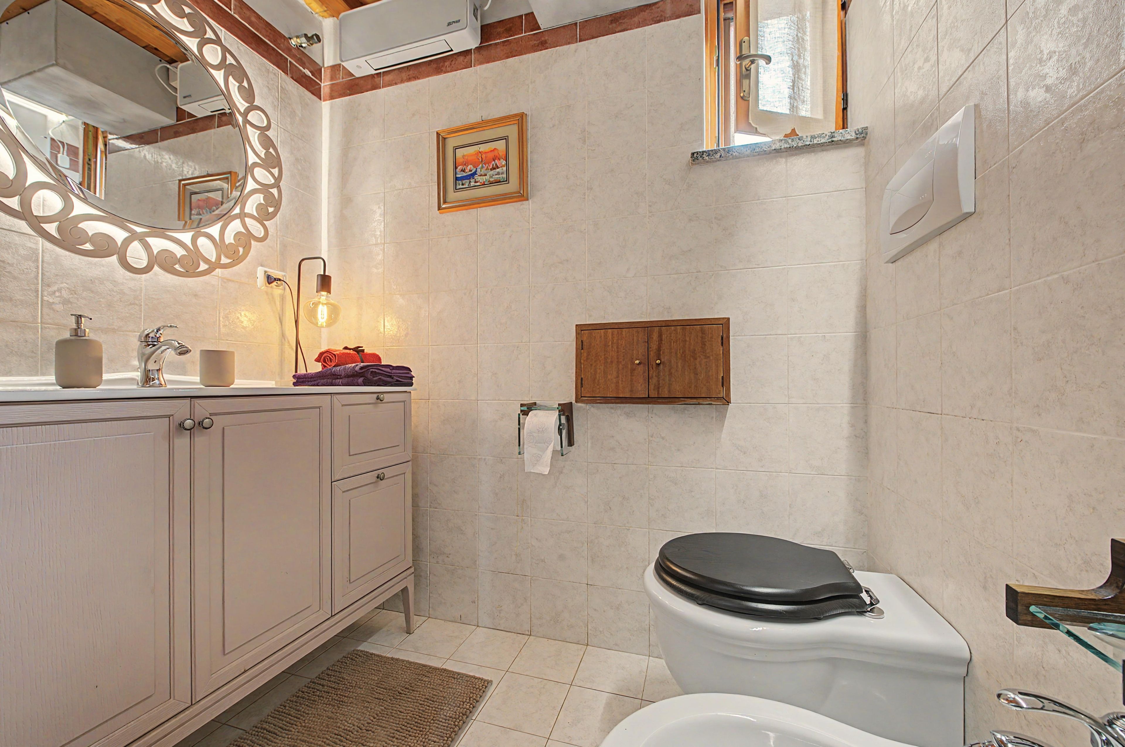 Une salle de bain avec des toilettes, un lavabo et un miroir.