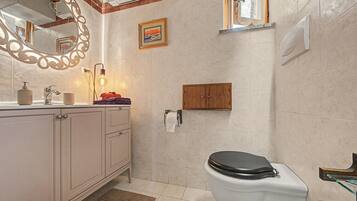 Une salle de bain avec des toilettes, un lavabo et un miroir.