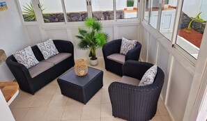 A sunlit room with two wicker sofas, a central coffee table, and a potted plant. - Villa Jude with private heated pool (Puerto del Carmen)