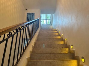Eine Treppe mit Handlauf und Wandleuchten.