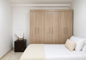 A bedroom with a bed, a nightstand, and a wardrobe. - Spacious 4-bedroom apartment in soothing Cartagena de Indias with AC (Cartagena de Indias)