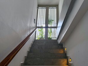 A staircase with a handrail, leading to a door with a metal gate. - Spacious 4-bedroom apartment in soothing Cartagena de Indias with AC (Cartagena de Indias)