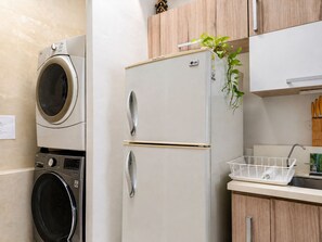 A kitchen with a washing machine, a refrigerator, and wooden cabinets. - Spacious 4-bedroom apartment in soothing Cartagena de Indias with AC (Cartagena de Indias)
