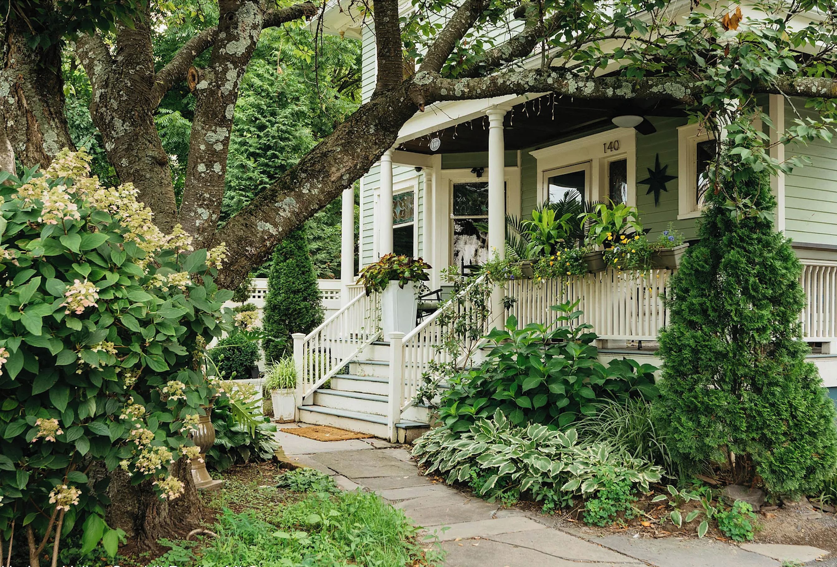 A house with a porch, a staircase, and a garden.