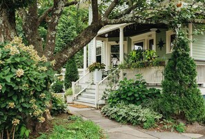 A house with a porch, a staircase, and a garden.