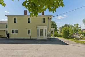 A two-story house with a bay window and a covered porch.