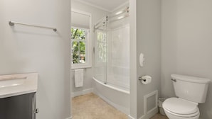 A bathroom with a bathtub, toilet, and a window. - The Federal Flat Steps From Downtown (Belfast)