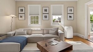 A living room with a sofa, a coffee table, a lamp, and framed pictures on the wall. - The Federal Flat Steps From Downtown (Belfast)