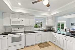 A modern kitchen with white cabinetry, a built-in oven, microwave, and a toaster. - Rotonda Getaway with Heated Pool & Lanai (Rotonda West)