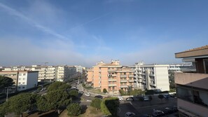 Ein Wohngebiet mit mehrstöckigen Gebäuden, einer Straße mit Fahrzeugen und Bäumen.