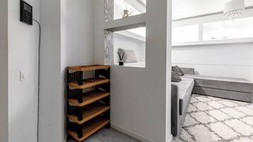 A modern interior with a built-in shelf unit, a window with a view, and a seating area with a patterned rug.