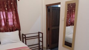 A bedroom with a bed, a wooden bench, a mirror, and a door leading to another room. - Echo Lodge (Habarana)