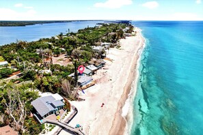 A coastal property with a beach, a pier, and a view of the ocean. - 2 BR/2 BA Beach Front Suite-Kayaks-SUPs-Bikes-Pets (Englewood)
