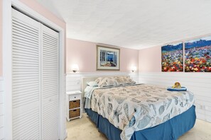 A bedroom with a bed, a nightstand, a wardrobe, and two wall-mounted lamps. - 2 BR/2 BA Beach Front Suite-Kayaks-SUPs-Bikes-Pets (Englewood)