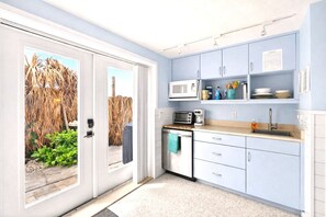 A compact kitchen with a microwave, toaster, and sink, featuring light blue cabinets and a small countertop. - 2 BR/2 BA Beach Front Suite-Kayaks-SUPs-Bikes-Pets (Englewood)