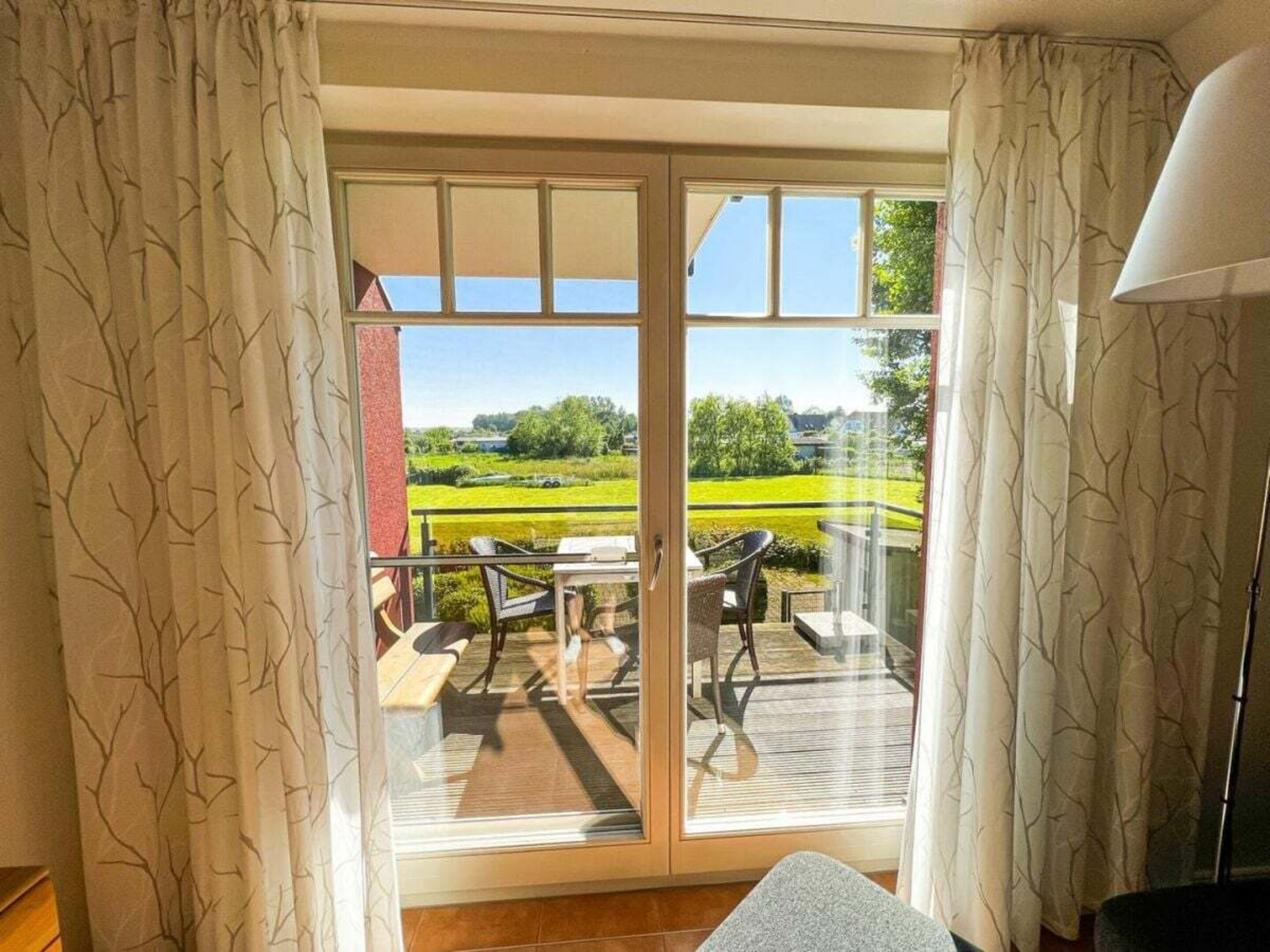A room with a sliding glass door leading to an outdoor deck with a table and chairs.