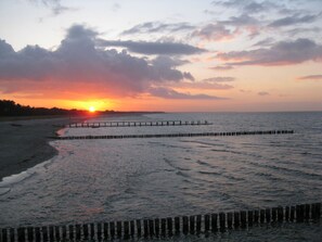 A beach with a wooden pier extending into the water during sunset. - Muhlenstrasse 19 Apartment 4 (Zingst)