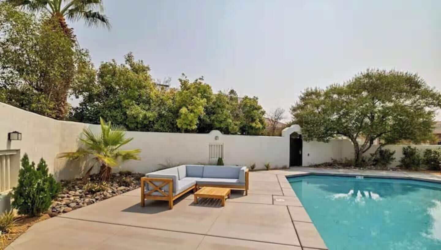 A poolside area with a built-in seating arrangement and a pool.