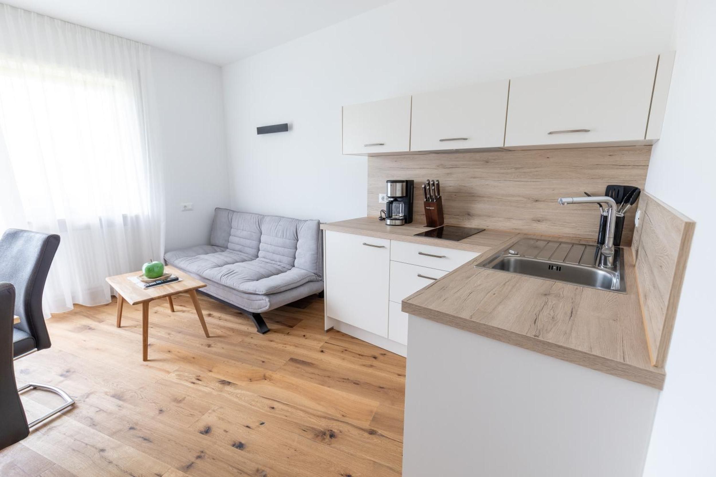 Una kitchenette compacta con cafetera, bloque de cuchillos y lavamanos.
