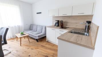 Una kitchenette compacta con cafetera, bloque de cuchillos y lavamanos.