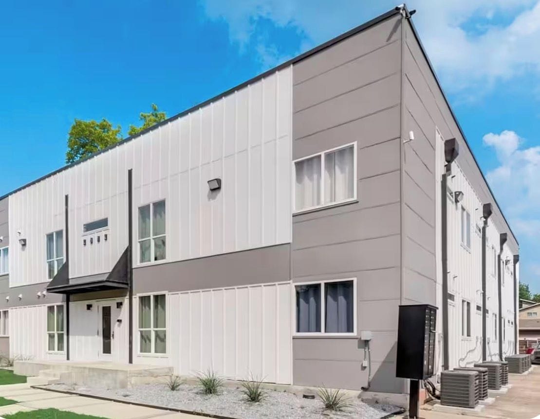 Een modern, twee verdiepingen hoog gebouw met een plat dak, grote ramen en een duidelijke entree.