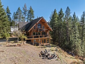 A log cabin with a balcony, surrounded by a forest. - Bottle Bay Beauty | Lake Views Near Sandpoint (Sagle)