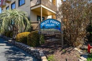 Schild für Inlet Point Villas mit Strandmotiv, einem verschlossenen Eingang und einem roten Hydranten.