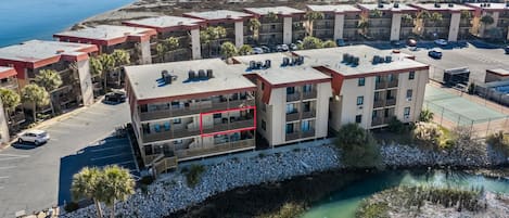 Un hotel de varios pisos con balcones, estacionamiento y vista a la playa.