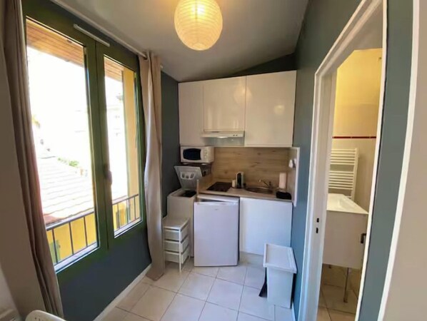 A compact kitchen with a microwave, sink, and cabinets.
