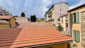 Un quartier résidentiel caractérisé par des toits recouverts de tuiles en terre cuite, des balcons et un ciel dégagé.