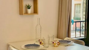 Une table à manger avec des chaises, une plante en pot et une bouteille.